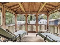 Cozy gazebo with lounge chairs overlooking wooded backyard, perfect for relaxing and entertaining at 308 Deep Creek Dr, Clayton, NC 27520
