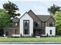 Modern two-story home with a mix of brick and wood siding, a large garage, and landscaping at 3705 Joyful Creek Trl, Zebulon, NC 27597