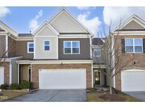 Townhouse exterior boasts stone and siding, a 2-car garage, and a charming front entrance at 5514 Jessip St, Morrisville, NC 27560