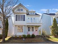 Charming two-story home features a balcony, pink door, and well-maintained landscaping at 1004 Gold Rock Ln, Morrisville, NC 27560
