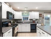 Bright kitchen features white cabinets, stainless steel appliances, and a window over the sink at 210 Scranton Ct, Cameron, NC 28326
