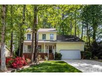 Beautiful yellow house with a spacious front yard, charming landscaping, and a two-car garage at 102 Pinehill Way, Cary, NC 27513