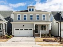 Charming two-story home with gray siding, attached garage, and inviting front porch at 1804 Bright Lantern Way, Wendell, NC 27591