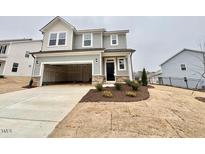 Charming two-story home featuring neutral siding, a two-car garage, and a well-maintained lawn at 202 Steel Springs Ln # 47, Angier, NC 27501