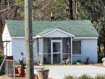 Charming single-story home featuring a cozy screened-in porch and American flag at 2313 Hunter Hill Rd, Rocky Mount, NC 27804