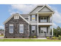 Attractive two-story home with gray siding, stone accents, and a welcoming double stacked front porch at 85 Kissington Way, Benson, NC 27504
