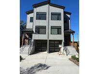Modern townhouse exterior featuring a concrete driveway, gray siding, and a shared two-car garage at 1105 Glascock St # 102, Raleigh, NC 27610