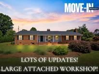 Charming single-story brick home featuring a welcoming front porch and beautifully landscaped front yard at 127 Fairfield Cir, Dunn, NC 28334