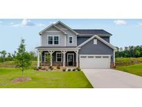 Beautiful two-story home with gray siding, stone accents, well-manicured lawn, and attached two car garage at 630 Contento Ct, Sanford, NC 27330