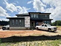 Modern two-story home with a flat roof, visible construction and a bright blue sky at 130 Broadleaf Ln, Louisburg, NC 27549
