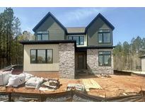 Modern two-story home with mixed siding and stone details, showcasing its contemporary design and curb appeal at 135 Cherry Bark Dr, Youngsville, NC 27596