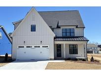 Charming two-story home with a white exterior, a two-car garage and professionally landscaped yard at 2006 Anna Lilley Dr # 72, Fuquay Varina, NC 27526