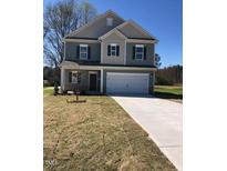 Two-story home featuring a two-car garage and neutral siding, located on a grassy lawn at 65 Vili Dr, Broadway, NC 27505