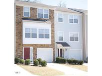Two-story townhome with stone and siding exterior, two-car garage, and landscaping at 1235 Stone Manor Dr, Raleigh, NC 27610