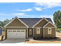 New construction home with green vinyl siding, white trim, and a two-car garage at 1236 Dover St # 58, Roxboro, NC 27573