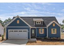 Newly constructed home with blue siding, white garage door, and landscaping at 1240 Dover St # 57, Roxboro, NC 27573