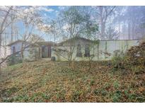 Ranch home with stucco exterior, situated on a wooded lot at 1405 Auman Rd, Raleigh, NC 27603