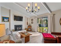 Cozy living room featuring a fireplace, wood floors, and sliding glass doors to the backyard at 205 Coachman Dr, Garner, NC 27529