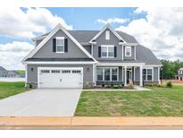 Charming two-story home featuring a two-car garage, well-maintained lawn and grey siding at 467 Ravensworth Dr, Garner, NC 27529