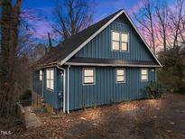 A charming blue house with a large deck and a wooded backdrop at 6708 Winding Trl, Raleigh, NC 27612