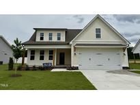 Charming home featuring a two-car garage, a well-manicured lawn, and a classic design at 107 Pretty Run Branch Ln, Wendell, NC 27591