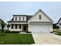 Charming two-story home with a two-car garage, green lawn, and covered front porch with wooden pillars at 107 Pretty Run Branch Ln, Wendell, NC 27591