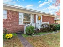 Brick ranch house with front porch, landscaping, and walkway at 3600 Nc 561, Louisburg, NC 27549