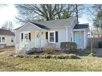 Charming house with light beige siding, white trim, and a light teal front door at 407 Somers Ave, Burlington, NC 27215