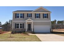 Charming two-story home featuring neutral siding, stone accents, a two-car garage, and a well-manicured front lawn at 45 Calabria Ct, Franklinton, NC 27525