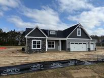 Charming single-story home featuring a two-car garage and stone and gray vinyl siding at 55 Surles Landing Way, Benson, NC 27504