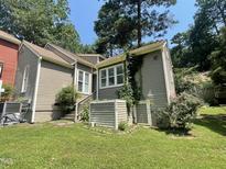 Charming home exterior featuring neutral siding, mature trees, and manicured lawn at 5718 Sentinel Dr, Raleigh, NC 27609