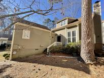 Two-story house with tan siding, landscaping, and a deck at 5718 Sentinel Dr, Raleigh, NC 27609