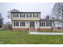 Two-story house with brick and siding, featuring a front porch and landscaped lawn at 802 S Sellars Mill Rd, Burlington, NC 27217