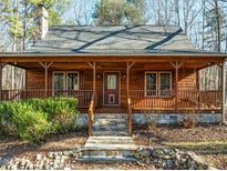 Wooden home with wraparound porch and stone steps, nestled in a wooded setting at 1018 Christy Ridge Ct, Rougemont, NC 27572