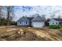 Newly constructed home with blue siding, a two-car garage, and a partially landscaped yard at 121 Tanglewood Dr # 8-J, Louisburg, NC 27549