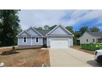 Charming single-story home with light blue siding, black roof, and a two car attached garage at 121 Tanglewood Dr # 8-J, Louisburg, NC 27549