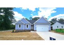 Charming one-story home with blue siding, a two-car garage, and a well-maintained lawn on a sunny day at 121 Tanglewood Dr # 8-J, Louisburg, NC 27549
