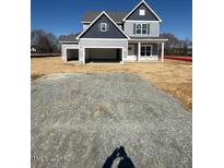 Charming two-story home featuring an attached two-car garage and a welcoming front porch at 123 Surles Landing Way, Benson, NC 27504