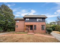 Brick two-story house with a black trimmed roof and landscaping at 126 Person St, Louisburg, NC 27549