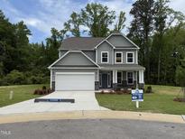 Charming two-story home with gray siding, a two-car garage, and a well-manicured lawn at 129 Stallion Way, Benson, NC 27504