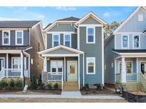 Two-story craftsman style home with light gray siding and a welcoming front porch at 144 Weavers Grove Dr, Chapel Hill, NC 27514