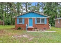 Brick ranch home with blue accents and a well-maintained lawn at 1558 Harper St, Rocky Mount, NC 27801
