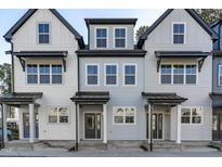 Three-unit townhome building, featuring light gray and white siding, dark gray doors, and front porches at 4821 Gossamer Ln # 106, Raleigh, NC 27616