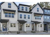Charming townhomes feature modern exteriors with covered entrances and beautiful architectural details at 8610 Brushfoot Way # 106, Raleigh, NC 27616
