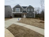 Charming two-story home with stone accents, attached garage, and front yard at 9349 Kitchin Farms Way # 463, Wake Forest, NC 27587