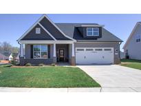 Two-story home with gray siding, white garage door, and landscaping at 1059 Fairhaven Dr # 55, Mebane, NC 27302