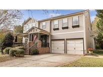 Two-story house with brick accents, attached garage, and a manicured lawn at 108 Cross Oaks Pl, Holly Springs, NC 27540