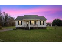 White house with brick base, front porch, and grassy yard at 131 Morgan Pkwy, Zebulon, NC 27597