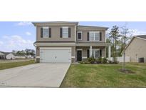 Two-story house with gray siding, white garage door, and landscaped lawn at 148 Cumberland Dr, Sanford, NC 27332
