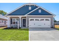 Newly constructed home with gray and blue siding, two car garage, and landscaped lawn at 168 Northwood Dr, Fuquay Varina, NC 27526